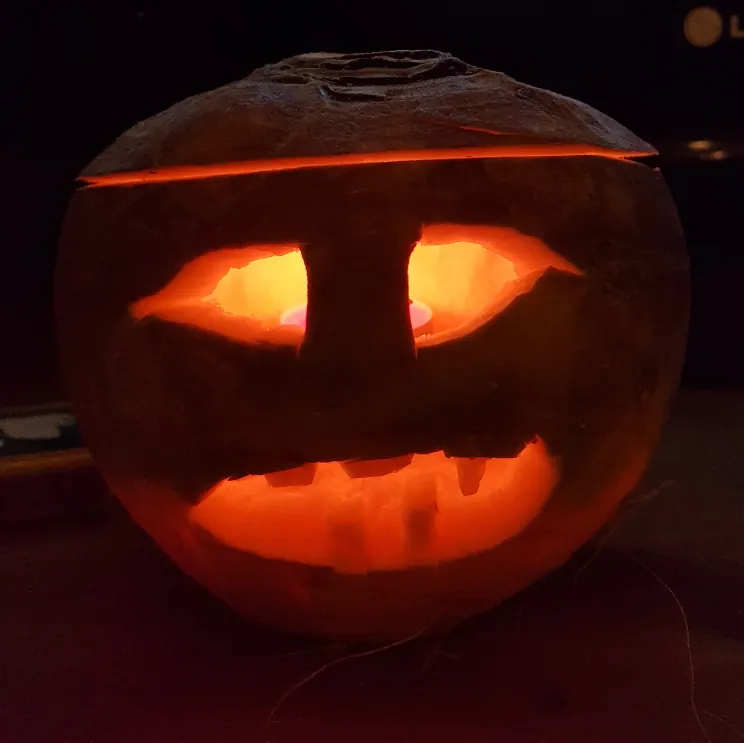 A scary face carved into a turnip. Shown in the dark with a small tealight inside to light up the features. Photo credit: Neil Williamson.